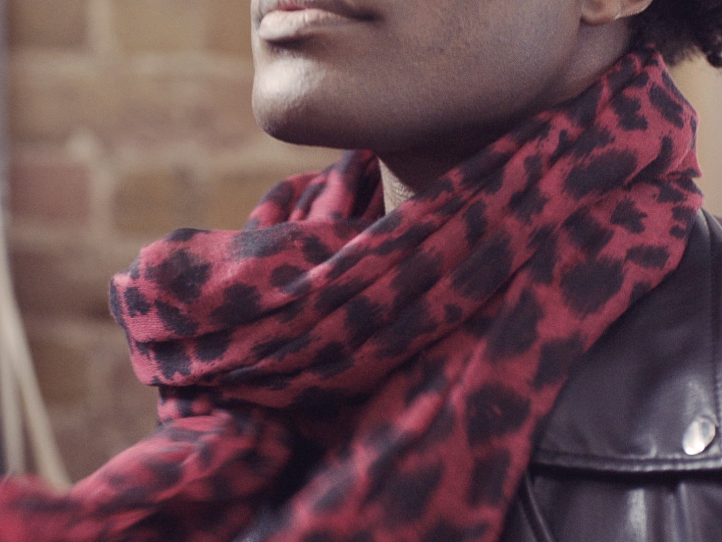 A guy draping a scarf round his neck.