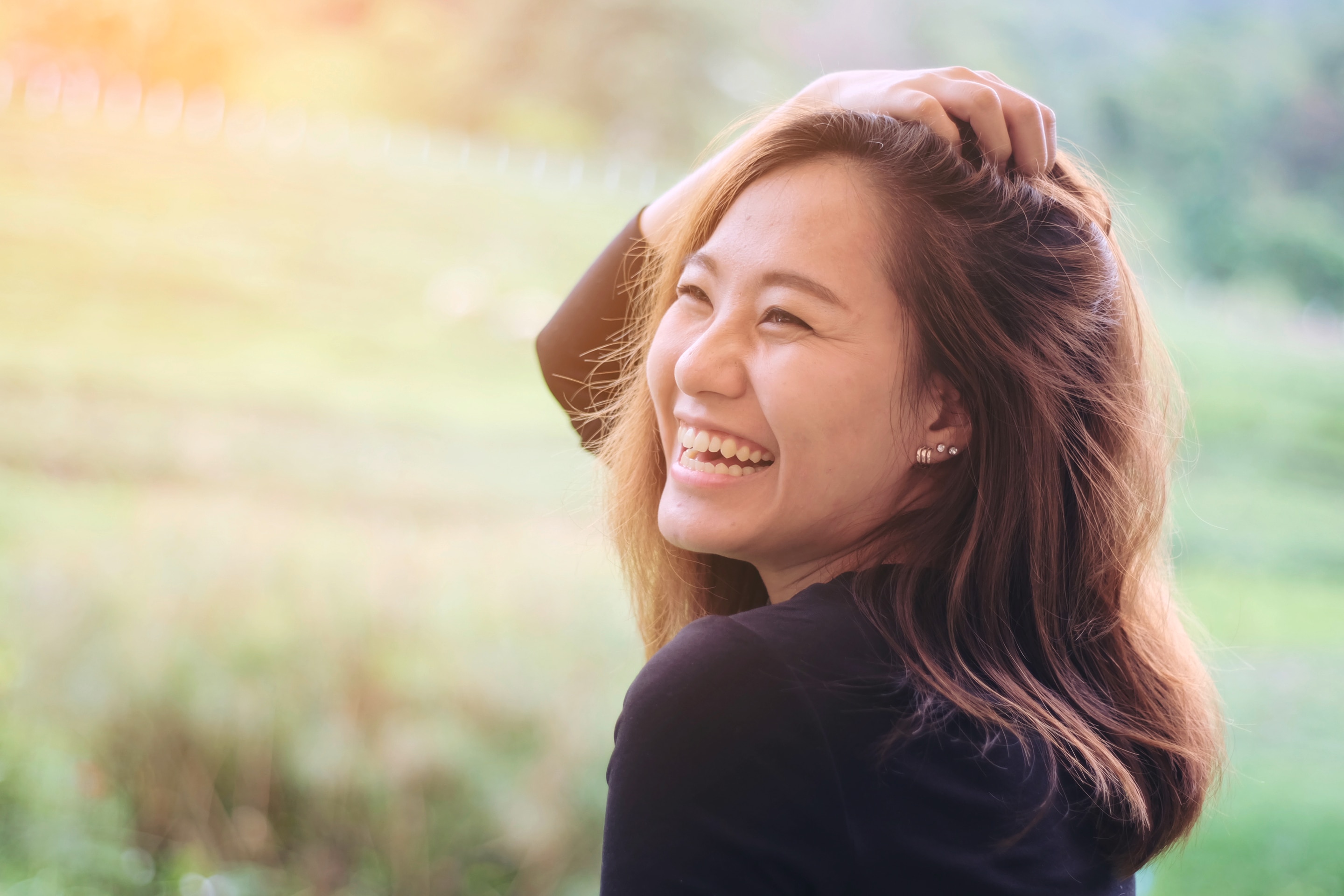 Woman smiling and ruffling her hair