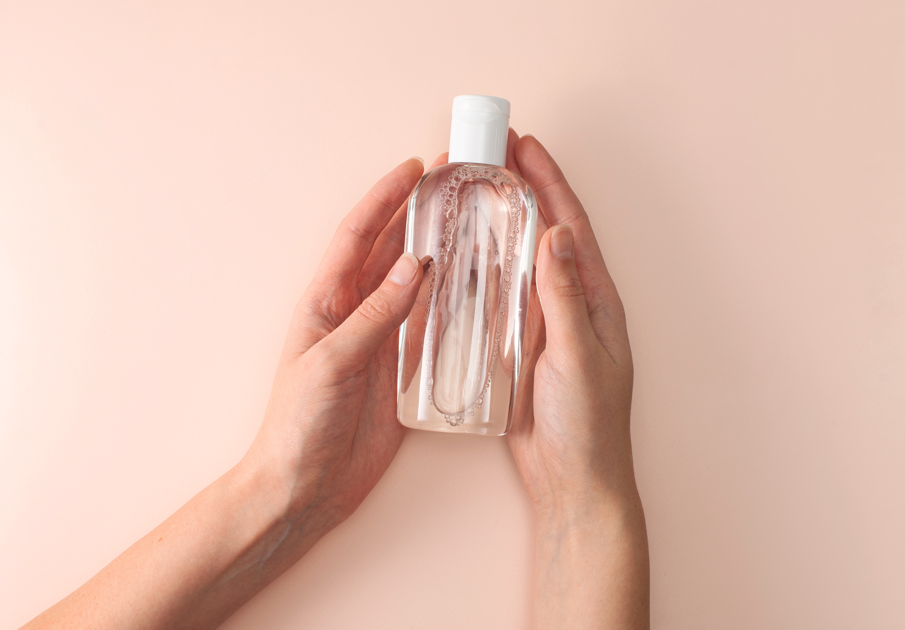 Woman holding a bottle of clear liquid