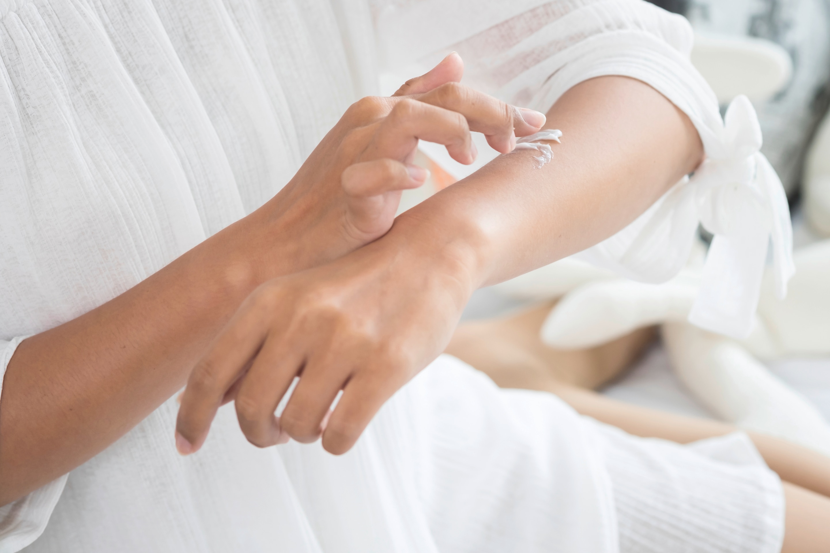 Woman applying topical buni treatment on her arm