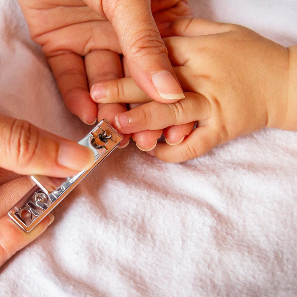 Mother cutting child's fingernails