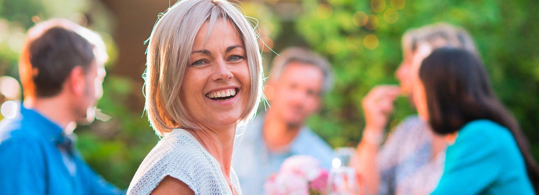 Une femme qui sourit avec ses amis dans un parc