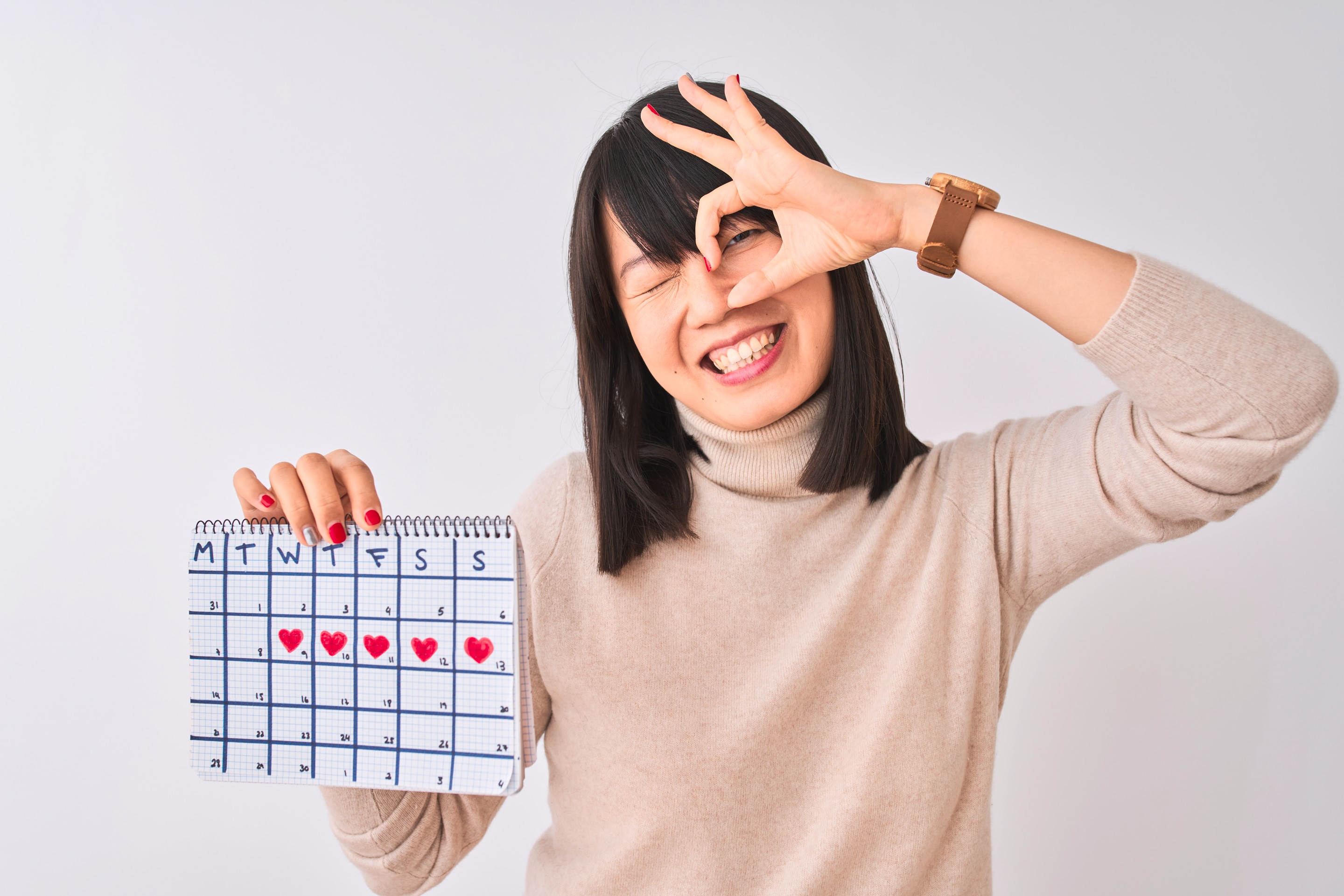 Asian woman holding a calendar of her cycle