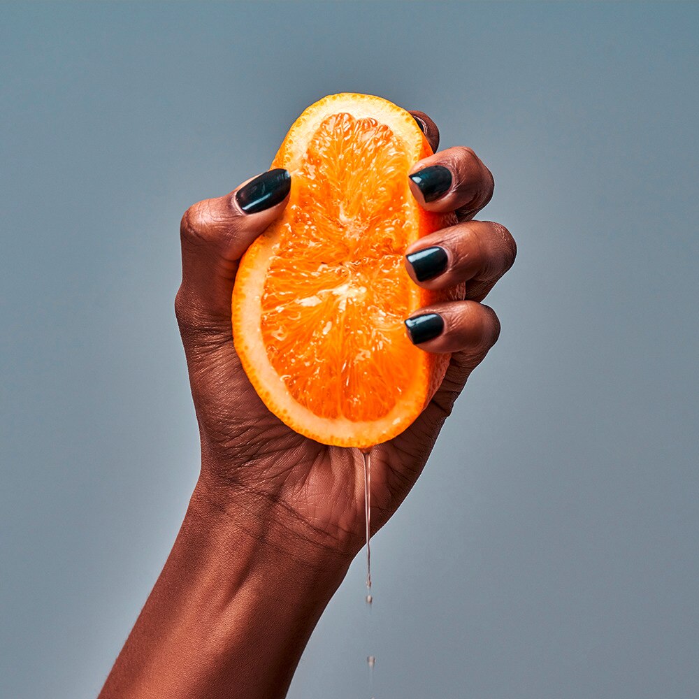 Woman squeezing juice from a citrus fruit