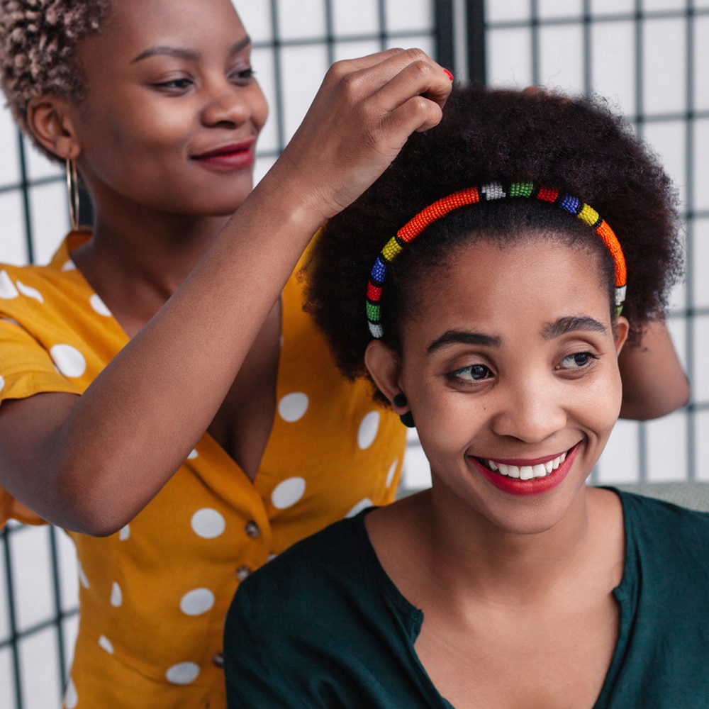Our Purpose - two women smiling whilst one is styling hair