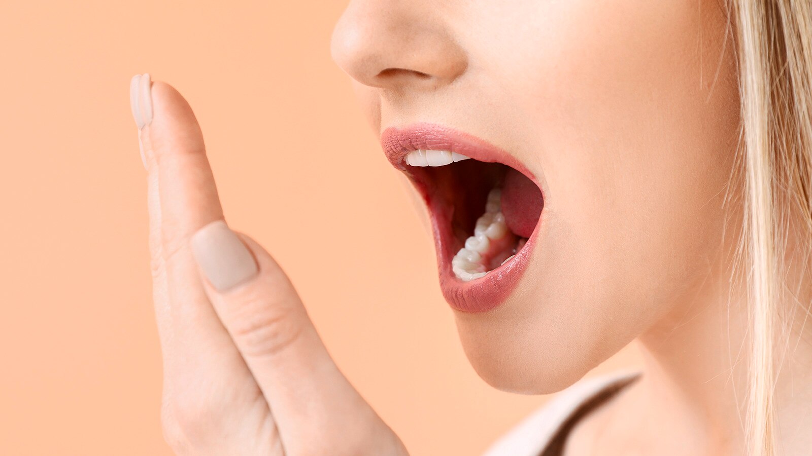 Two women and one man sitting at a table outside a restaurant and shaking hands