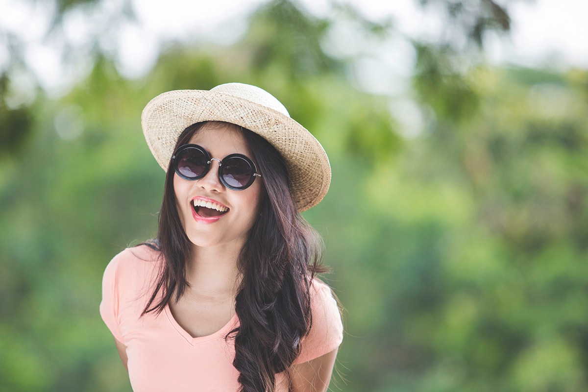 Asian girl wearing sunglasses and straw hat