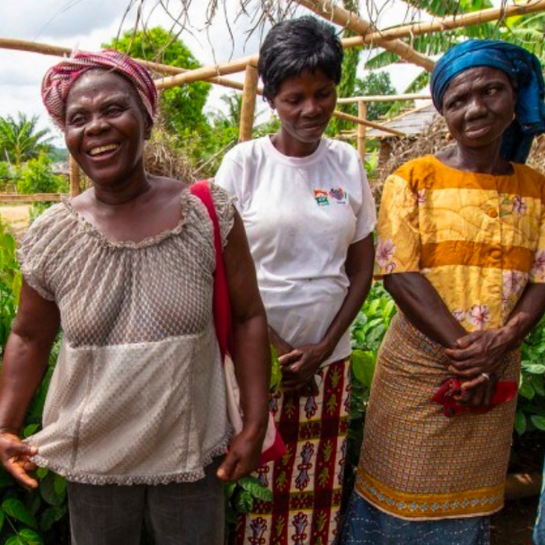 Trois cultivatrices de cacao souriantes, debout
