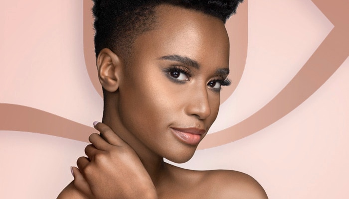 Zozibini Tunzi smiling with her hand behind her neck