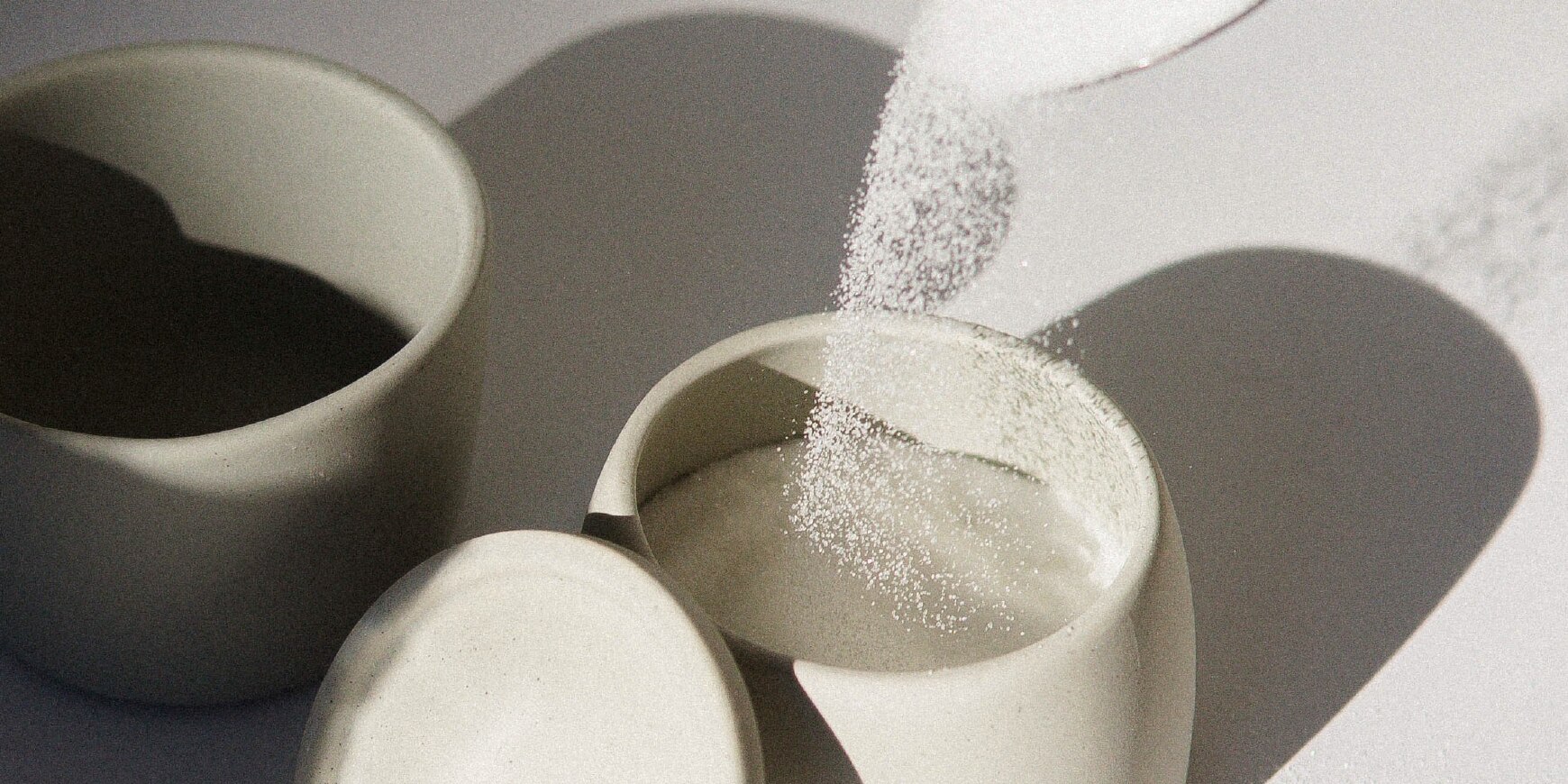 Spoonful of sugar falling in cup