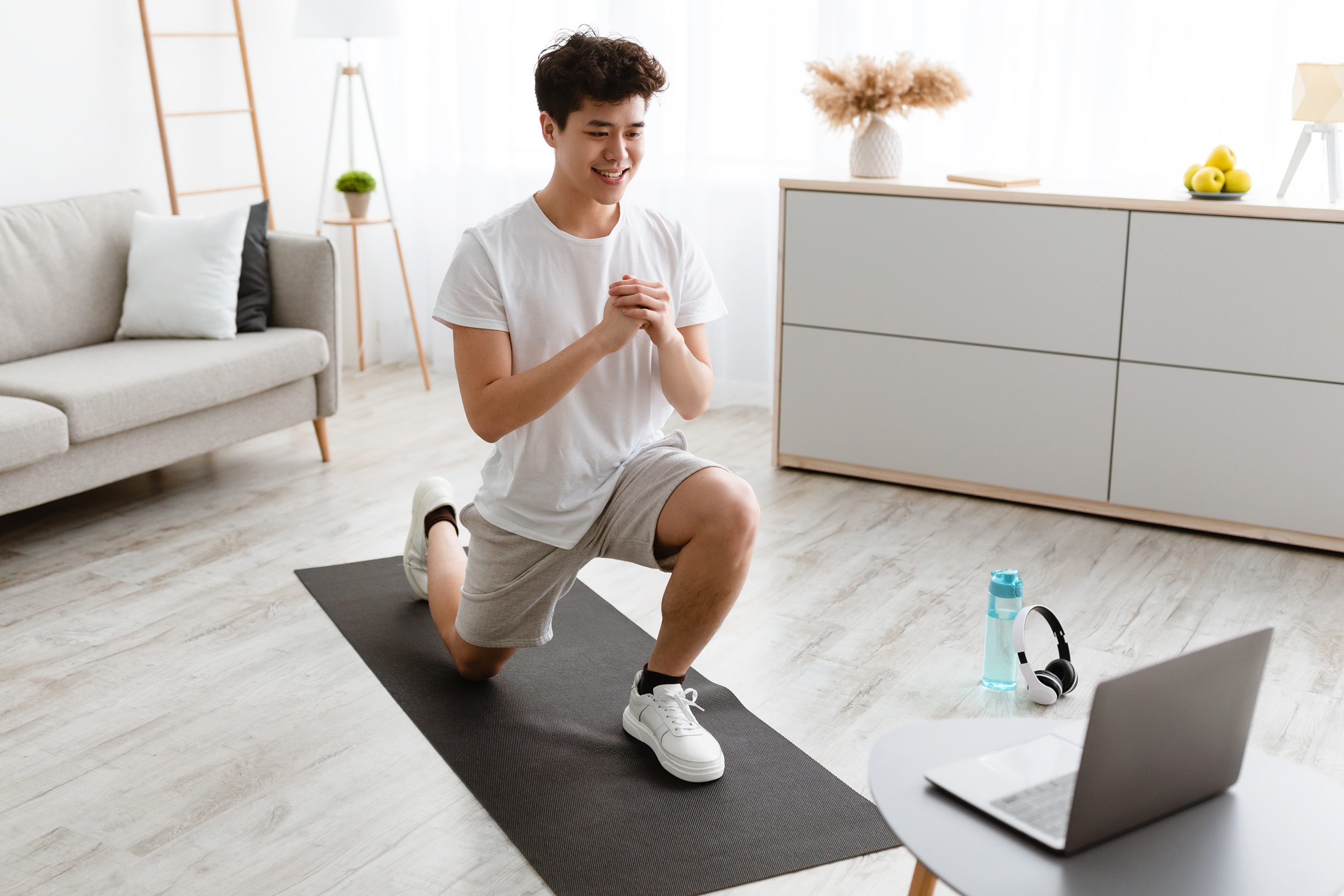 pria sedang melakukan gerakan workout di rumah berupa lunges