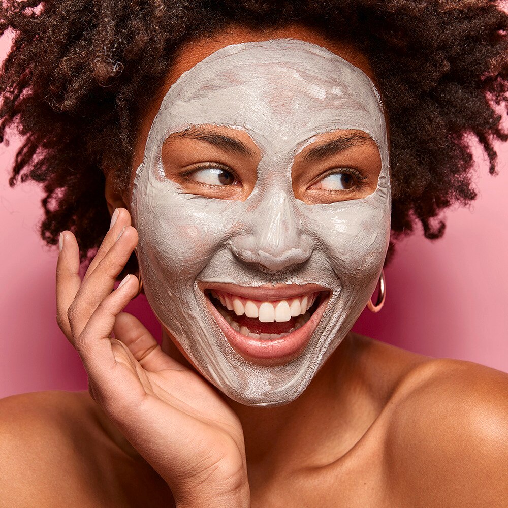 Woman with a clay face mask on her face.
