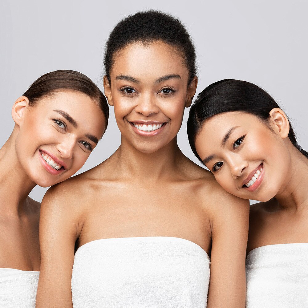 Three multiracial women wrapped in a towel