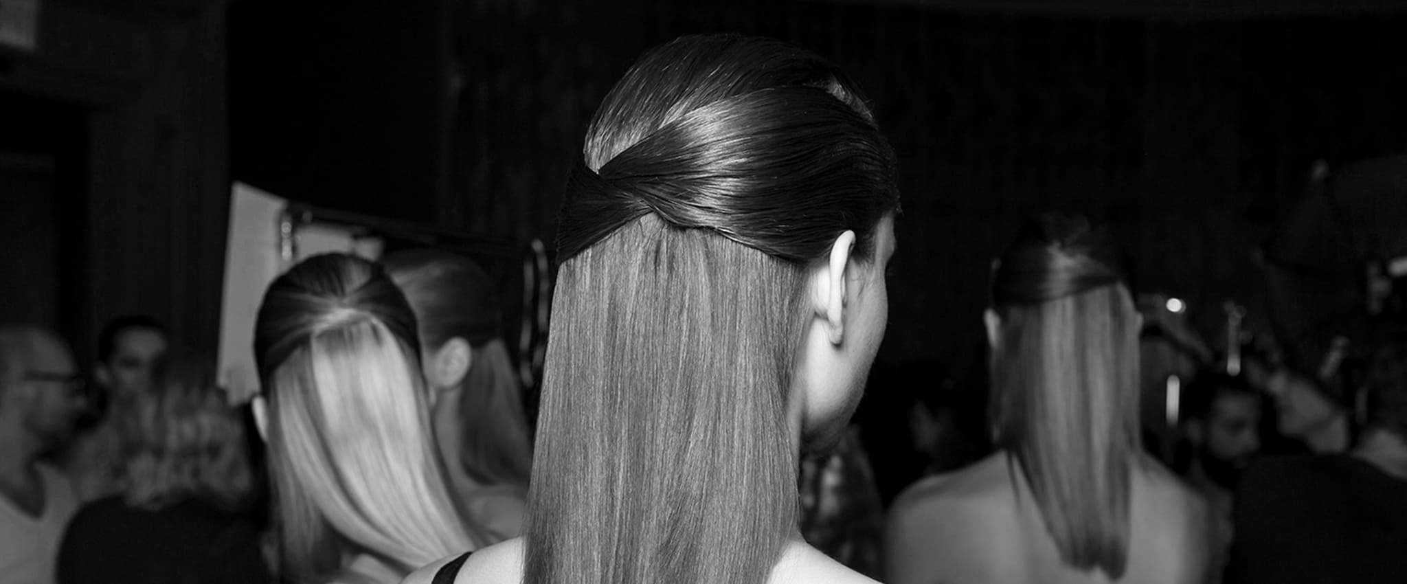 Close up of a heated styling tool being applied to a section of long dark hair.