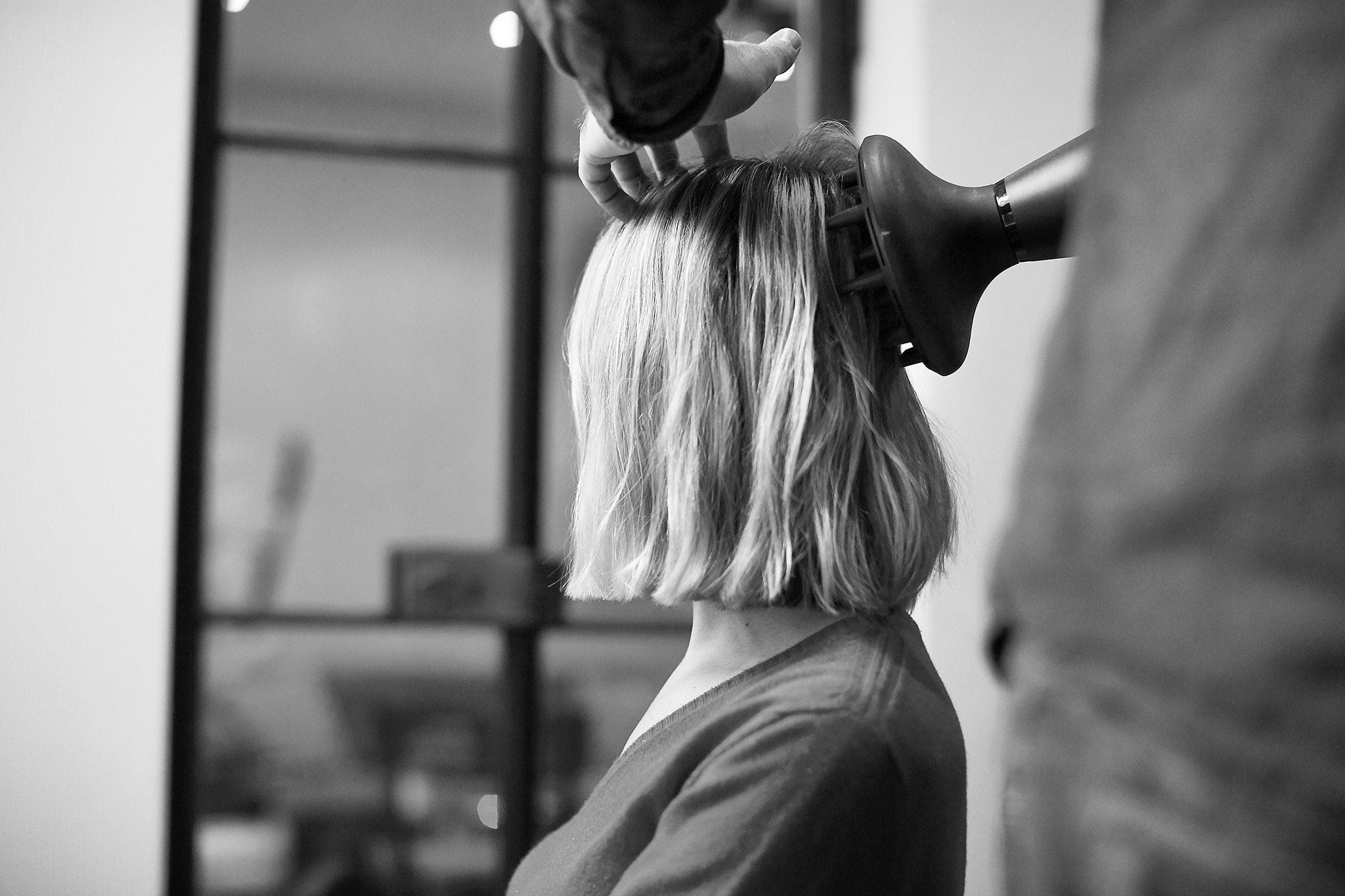 Projektantka Misha Nonoo w czasie stylizacji włosów przez fryzjera przy użyciu dyfuzora