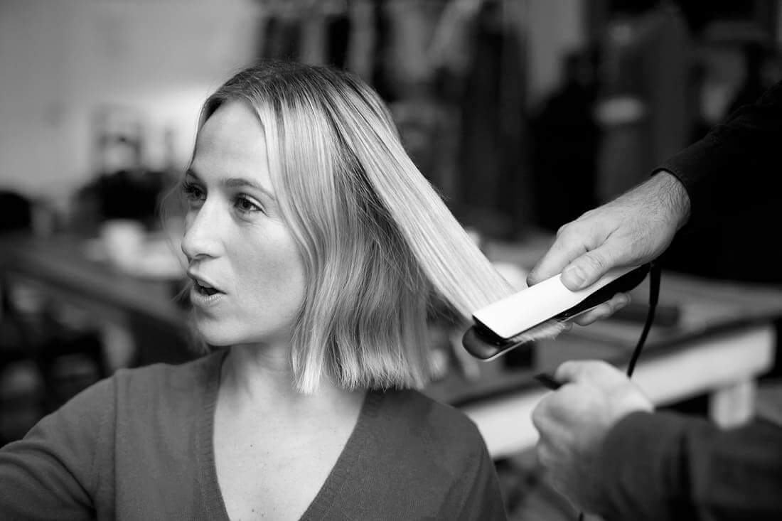 Designer Misha Nonoo with a stylist using a pair of straighteners on her hair 