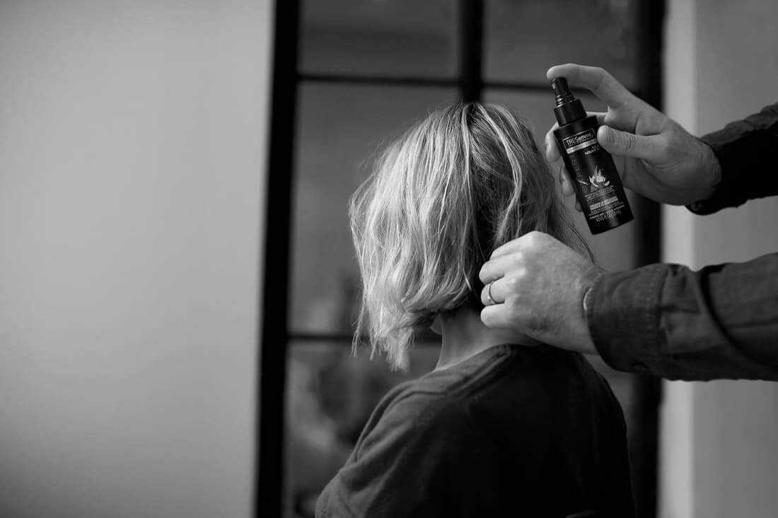 A estilista Misha Nonoo com um cabeleireiro usando um spray em seu penteado finalizado 