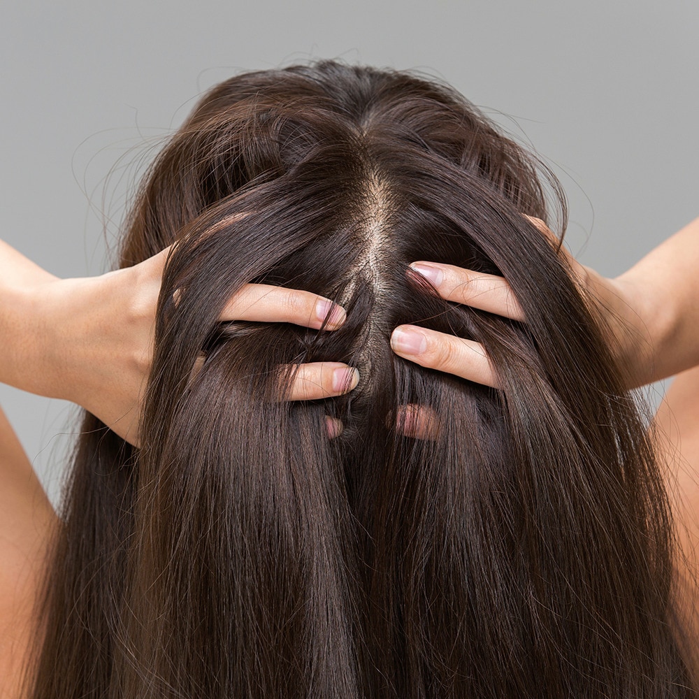 Back view of a woman running her fingers through her hair