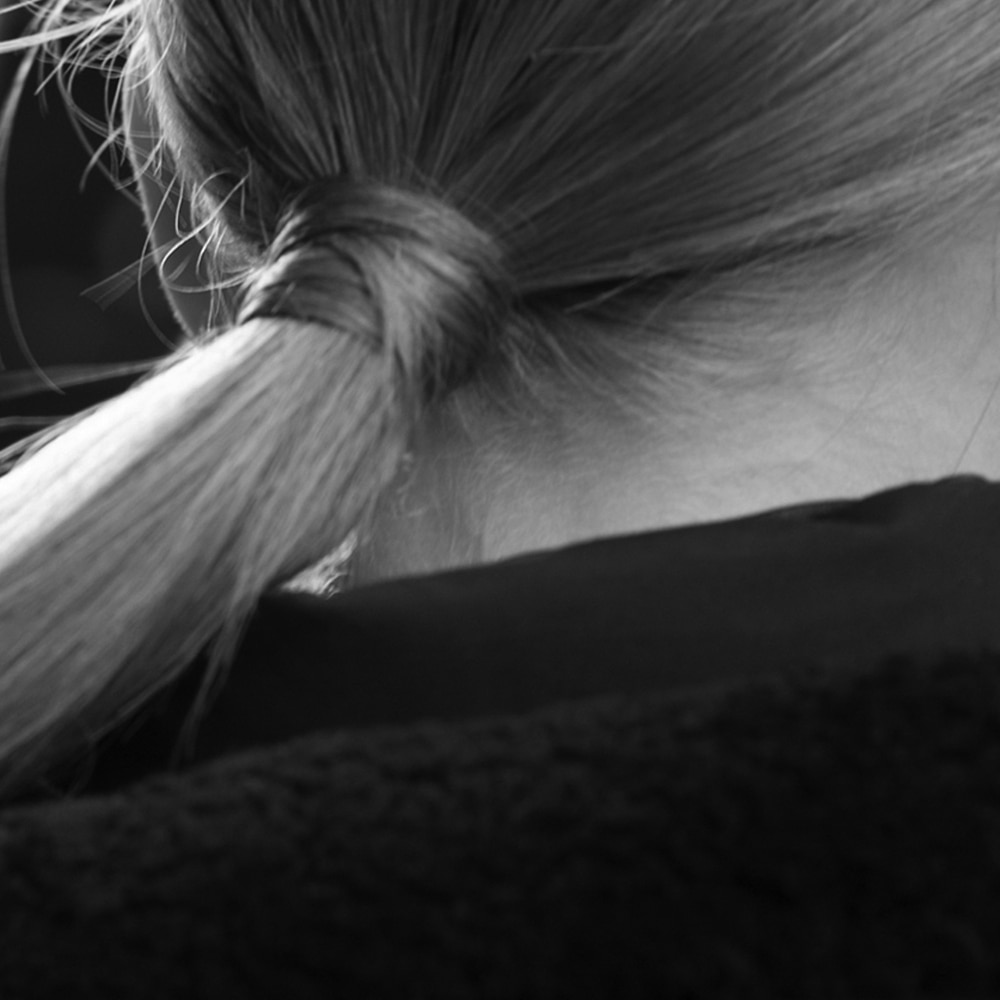 Close up of the back of a woman's head with a long blonde ponytail