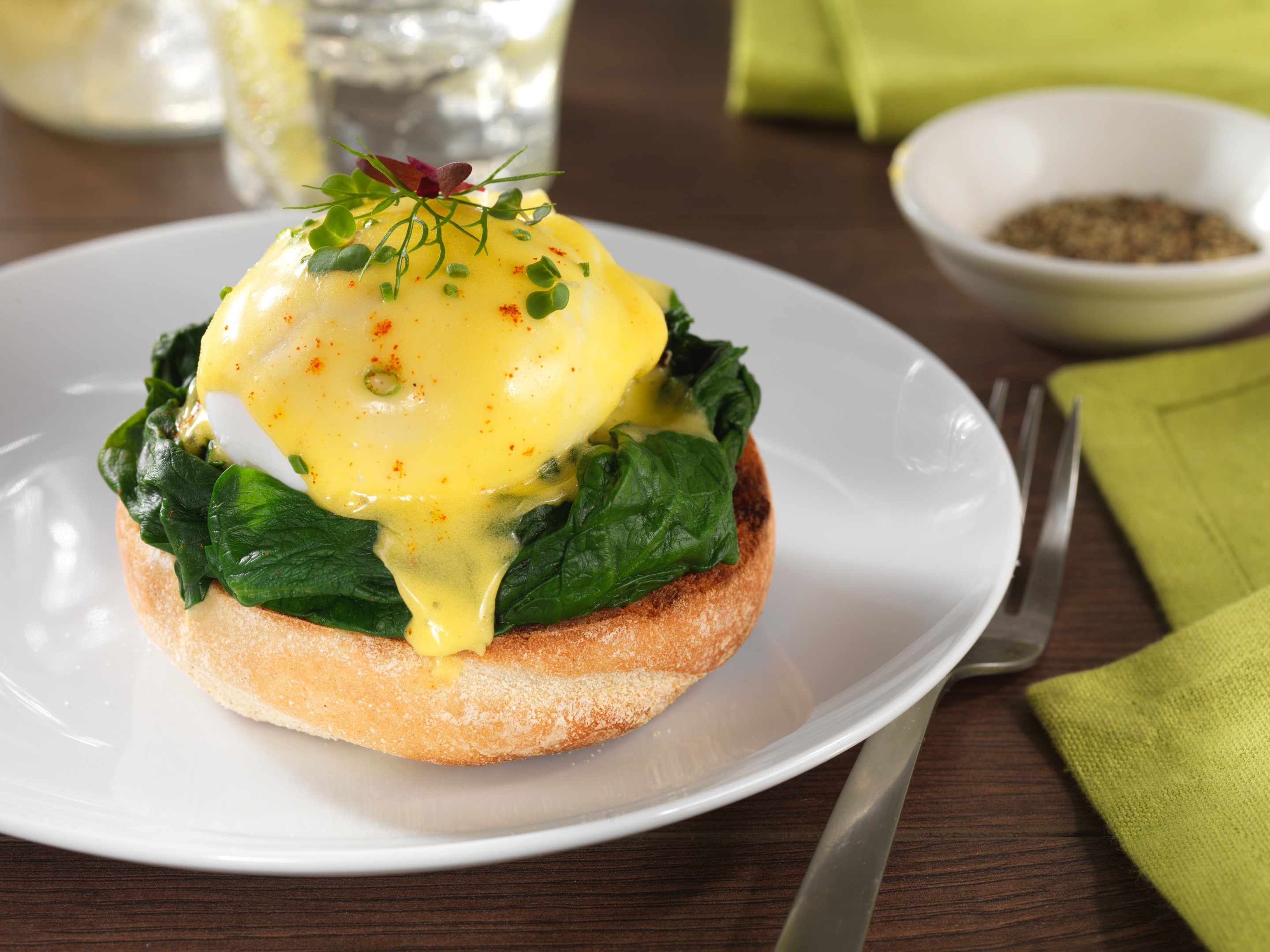 Eggs Florentine on a white plate with steel fork
