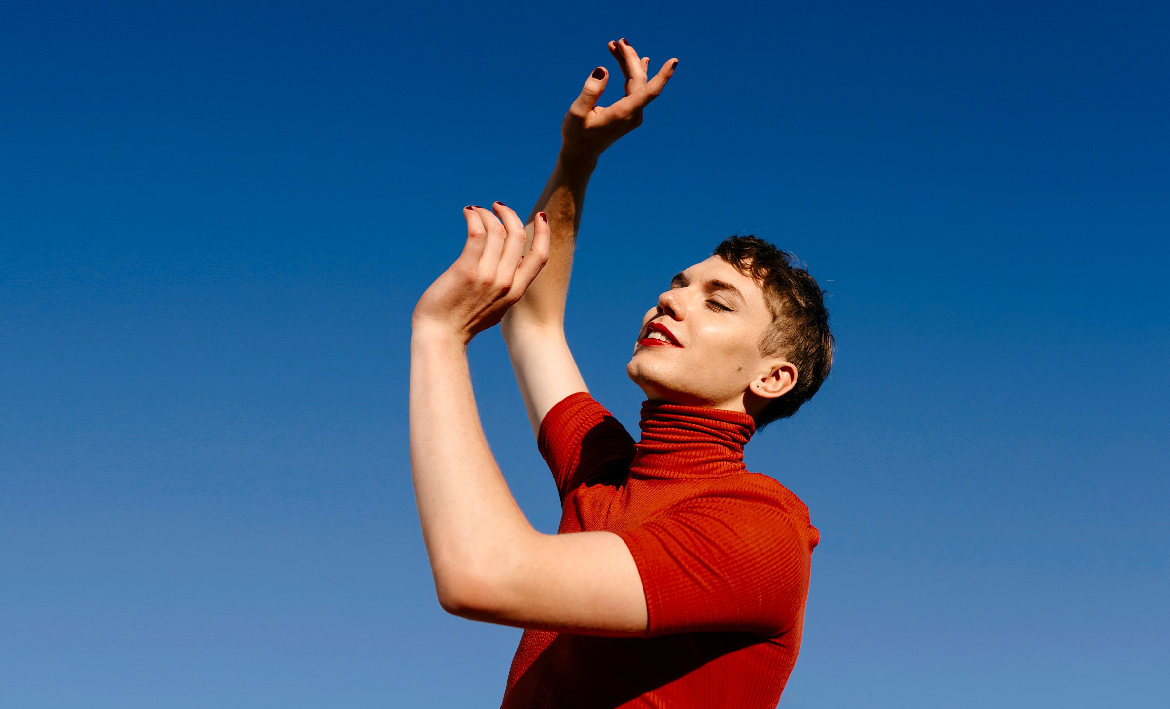 person jumping under a blue sunny sky