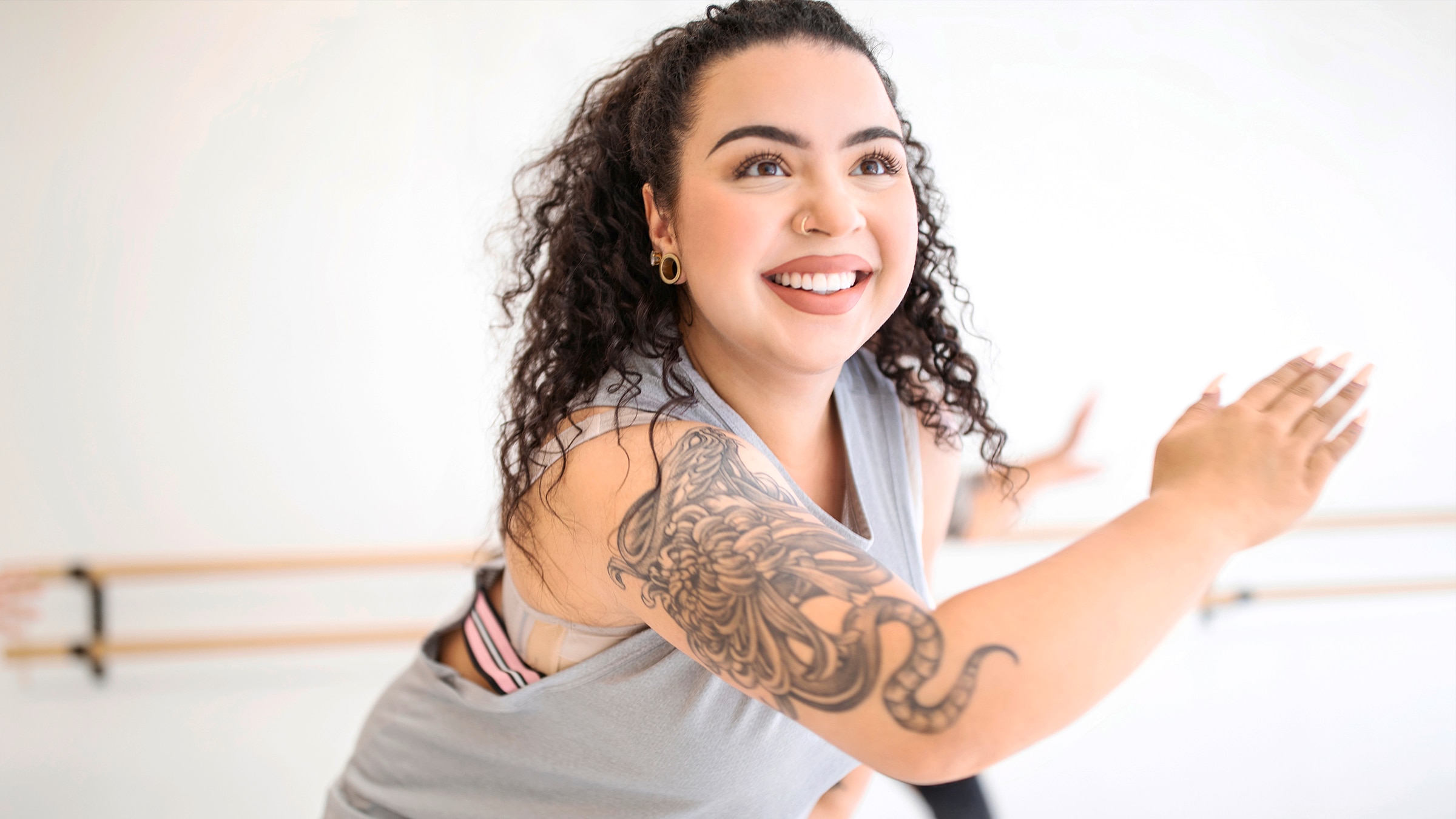 woman with tattooed arm dancing indoors