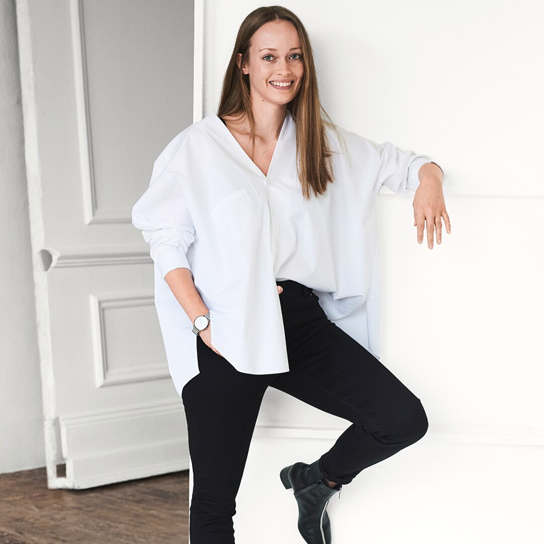 Kathrin, editora en línea, sonriendo y practicando yoga, reflejando su belleza real y confianza.