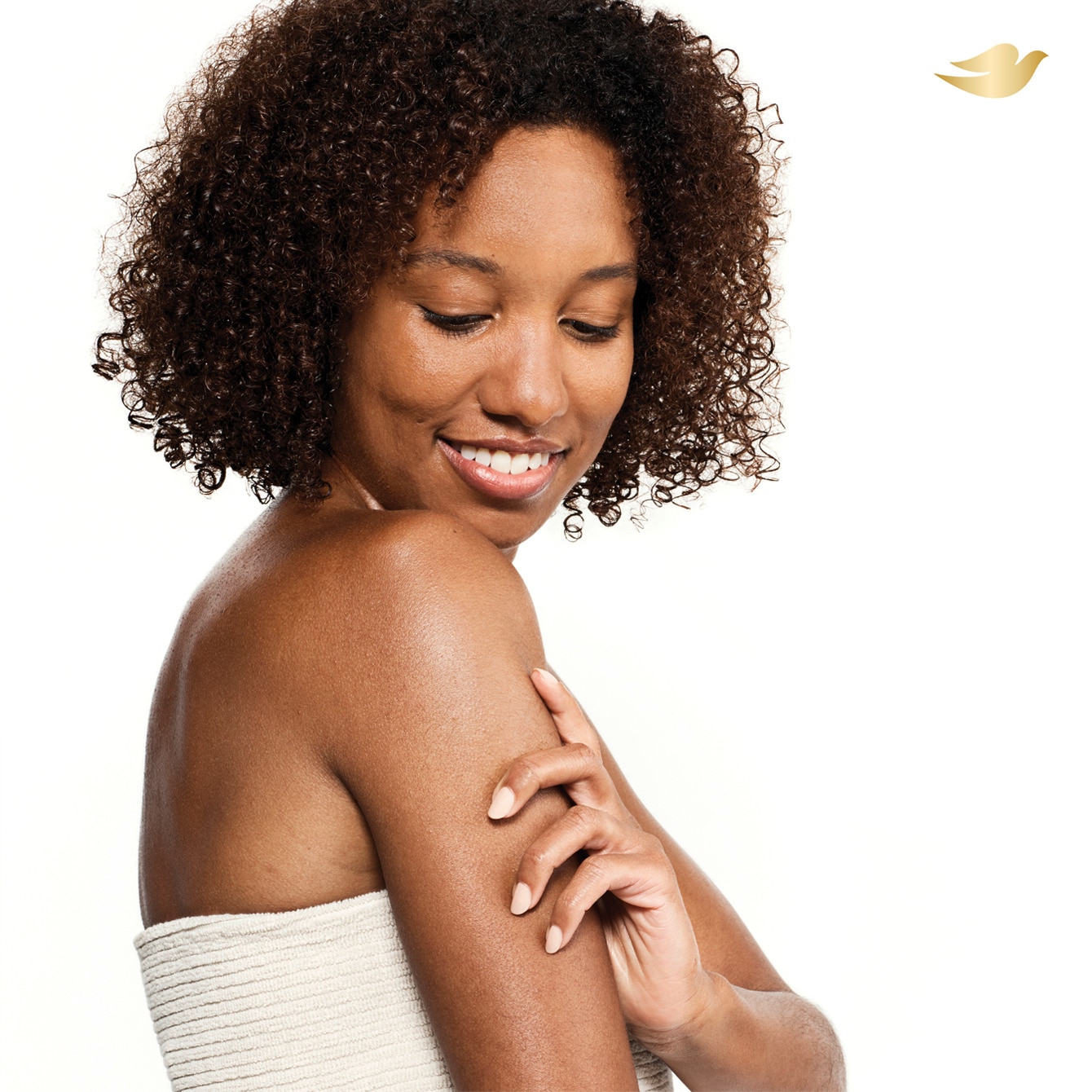A beautiful woman with curly hair smiling over her shoulder