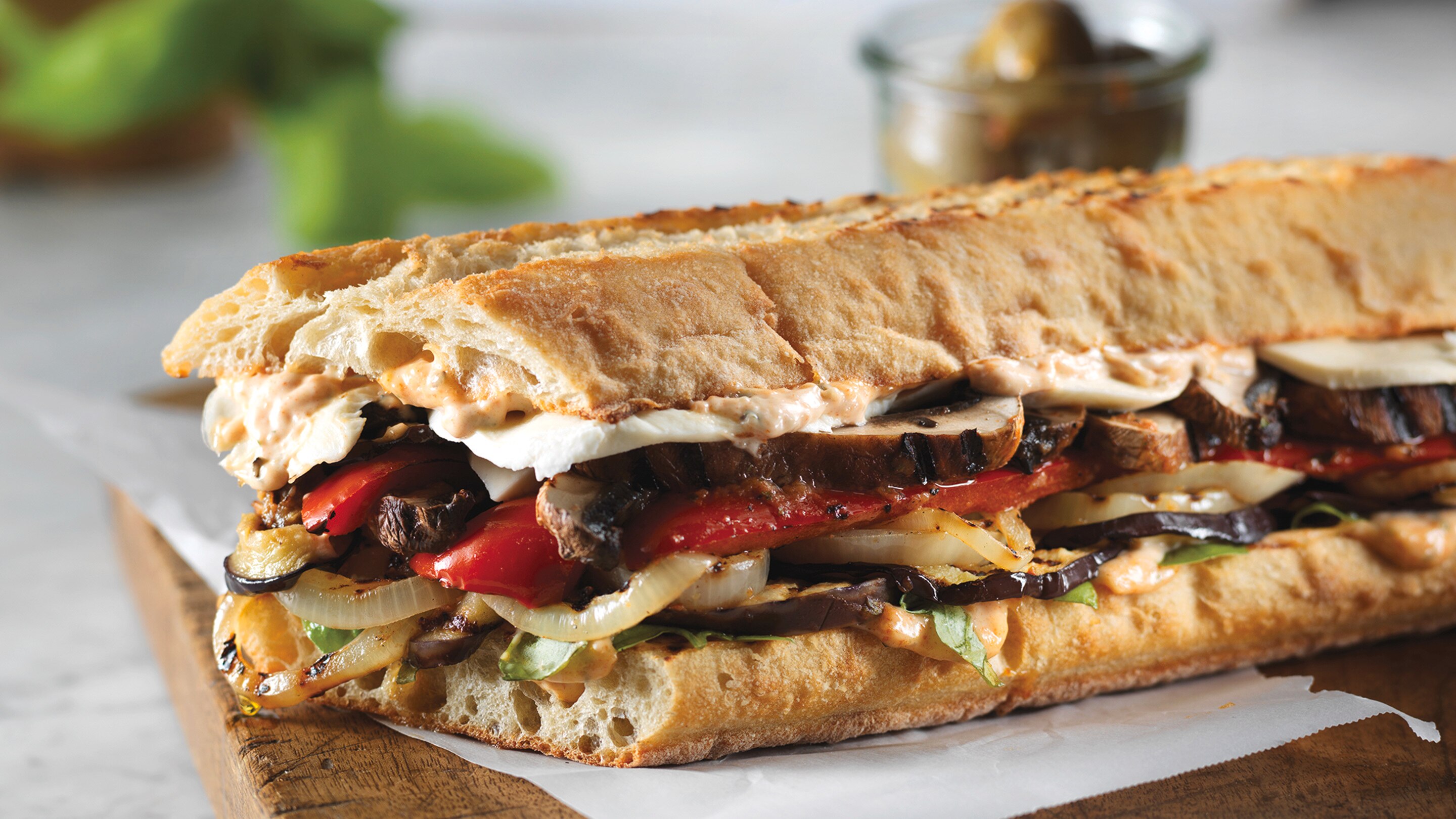 Bagette sandwich with layers of grilled vegetables and cheese