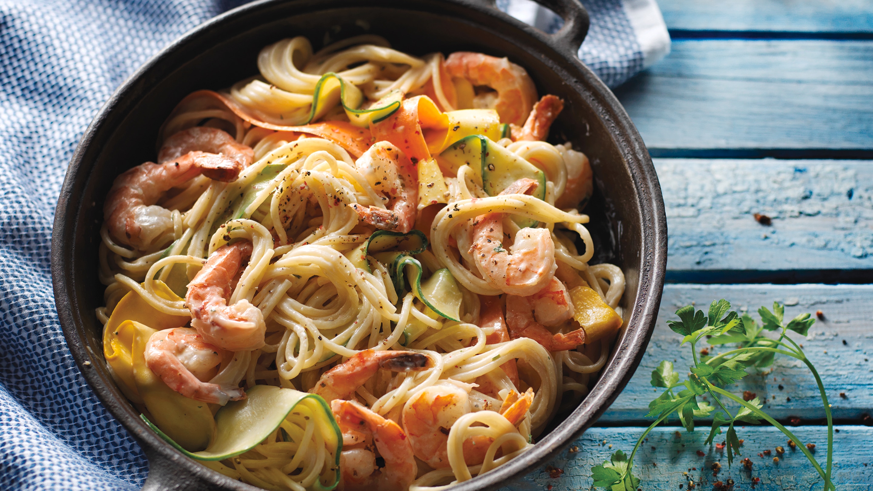 Spaghetti with shrimp and vegetable noodles in cast iron pan