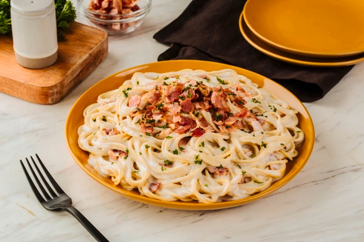A bowl of Pinoy-style Carbonara with bacon and parsley 