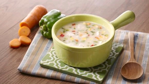 Creamy Mushroom Soup served in a green ramekin with bits of vegetables in it