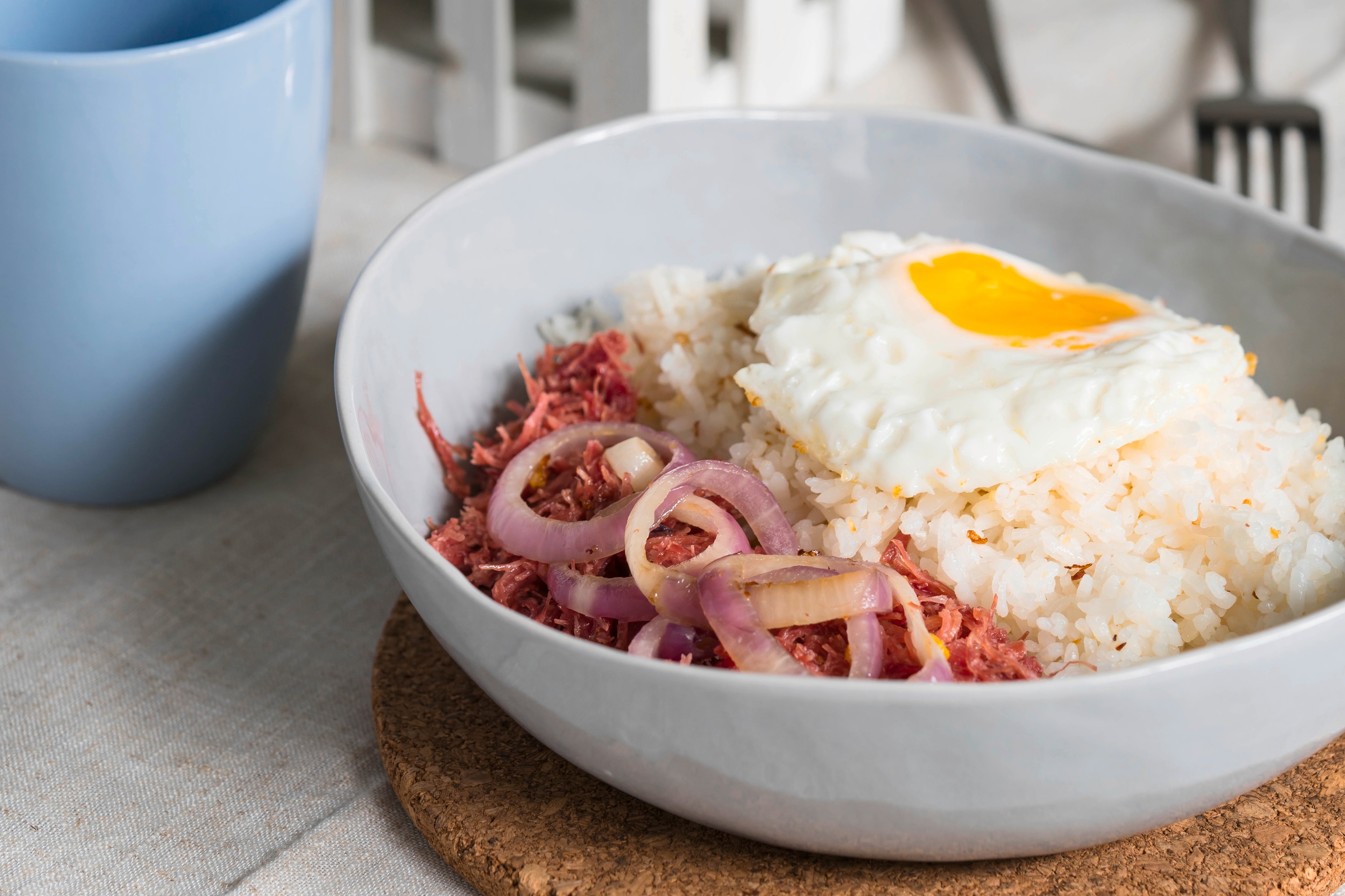 Classic Filipino corned beef hash for breakfast served with fried rice and sunny side up egg
