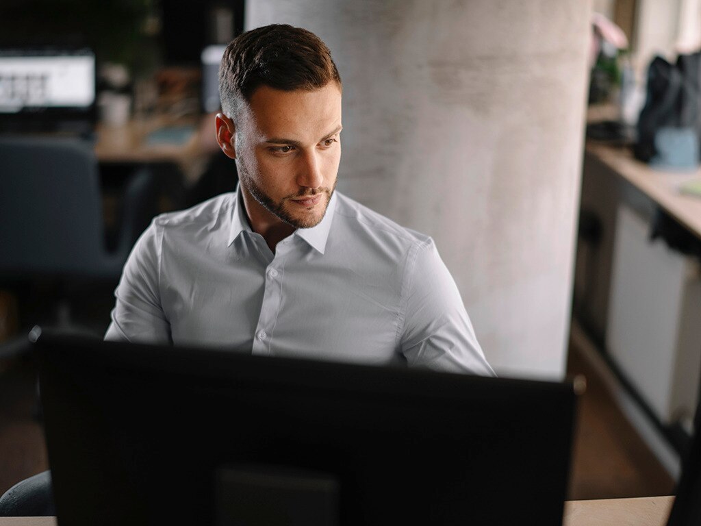 Hombre de pelo corto y look estilizado hacia el lado, trabajando en una oficina