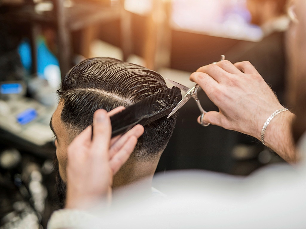 Elaboración de corte de pelo en hombres estilo degradé en barbería 