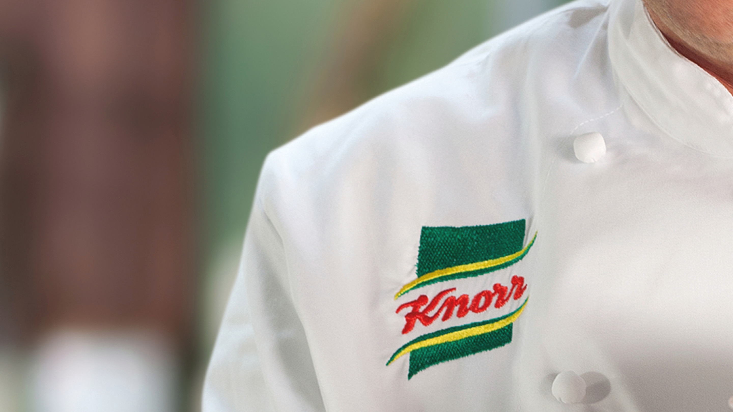 Gros plan sur le logo brodé de Knorr sur une blouse de chef