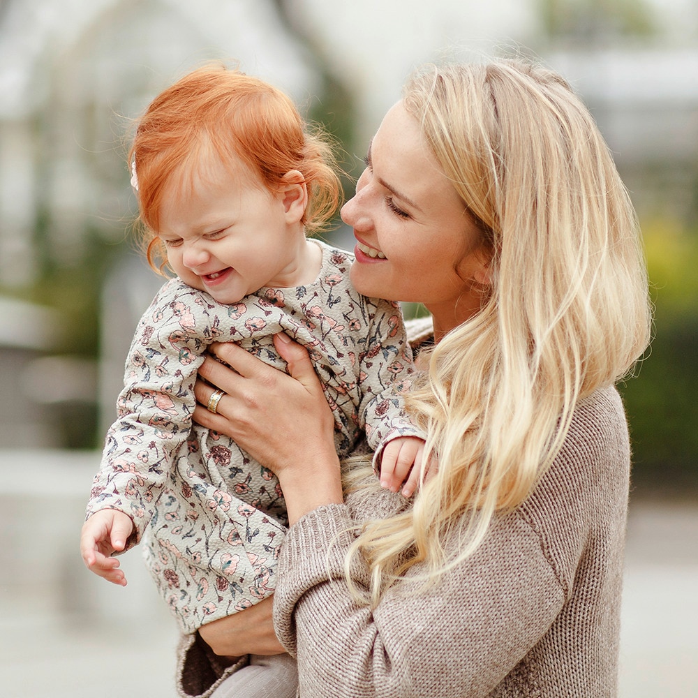 Blonde mom carrying a baby with red hair