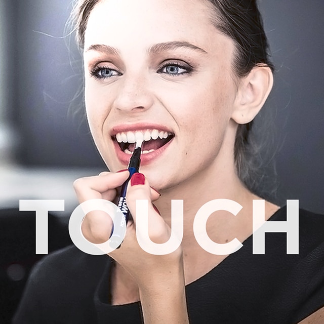 Vrouw gebruikt White Now Touch op haar tanden