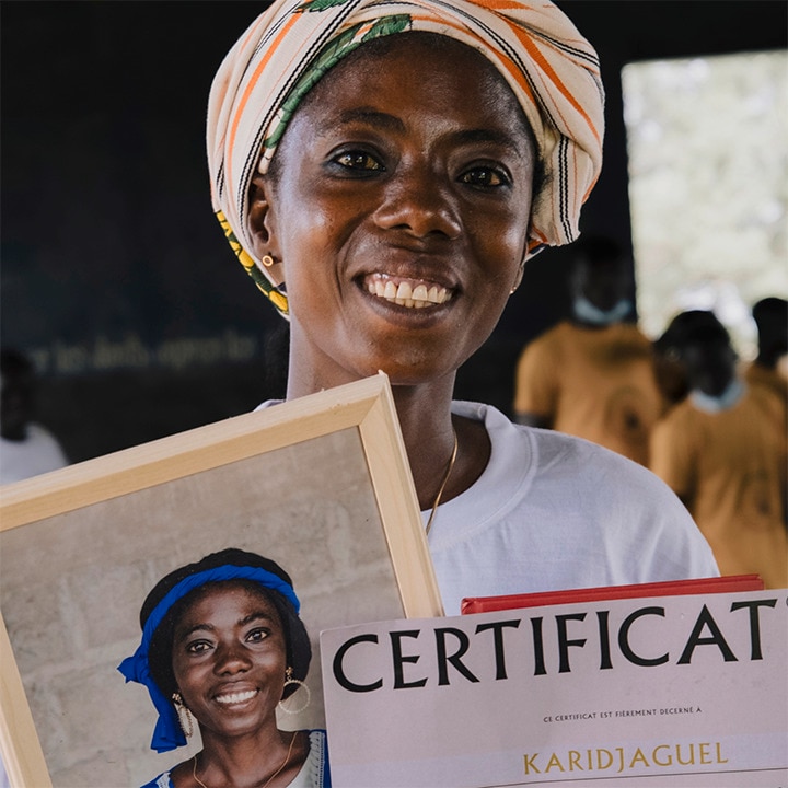 African woman holding certificate of achievement