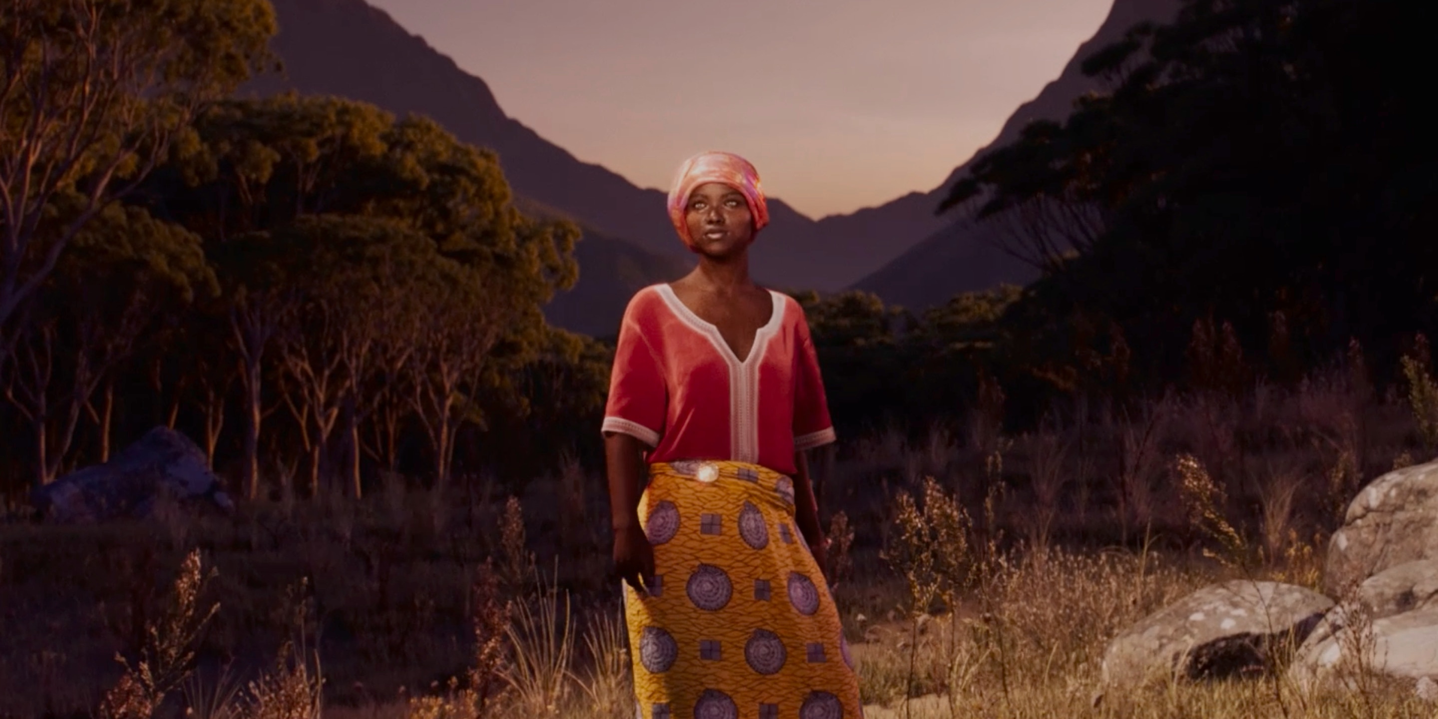 Afrikanische Frau vor einer afrikanischen Berglandschaft