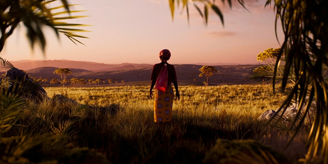African woman facing away standing in the savannah