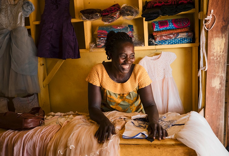 Mujeres africanas sonrientes con su colección de ropa