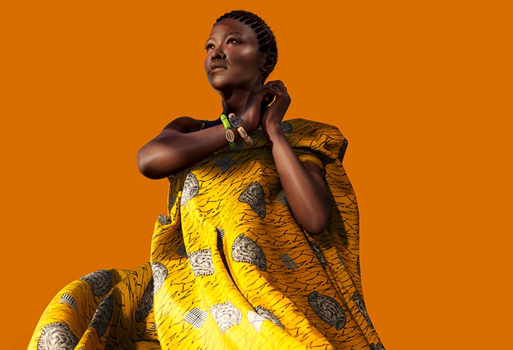 Modefotografie von AWA, der digitalen Botschafterin, vor einem leuchtend orangefarbenen Hintergrund