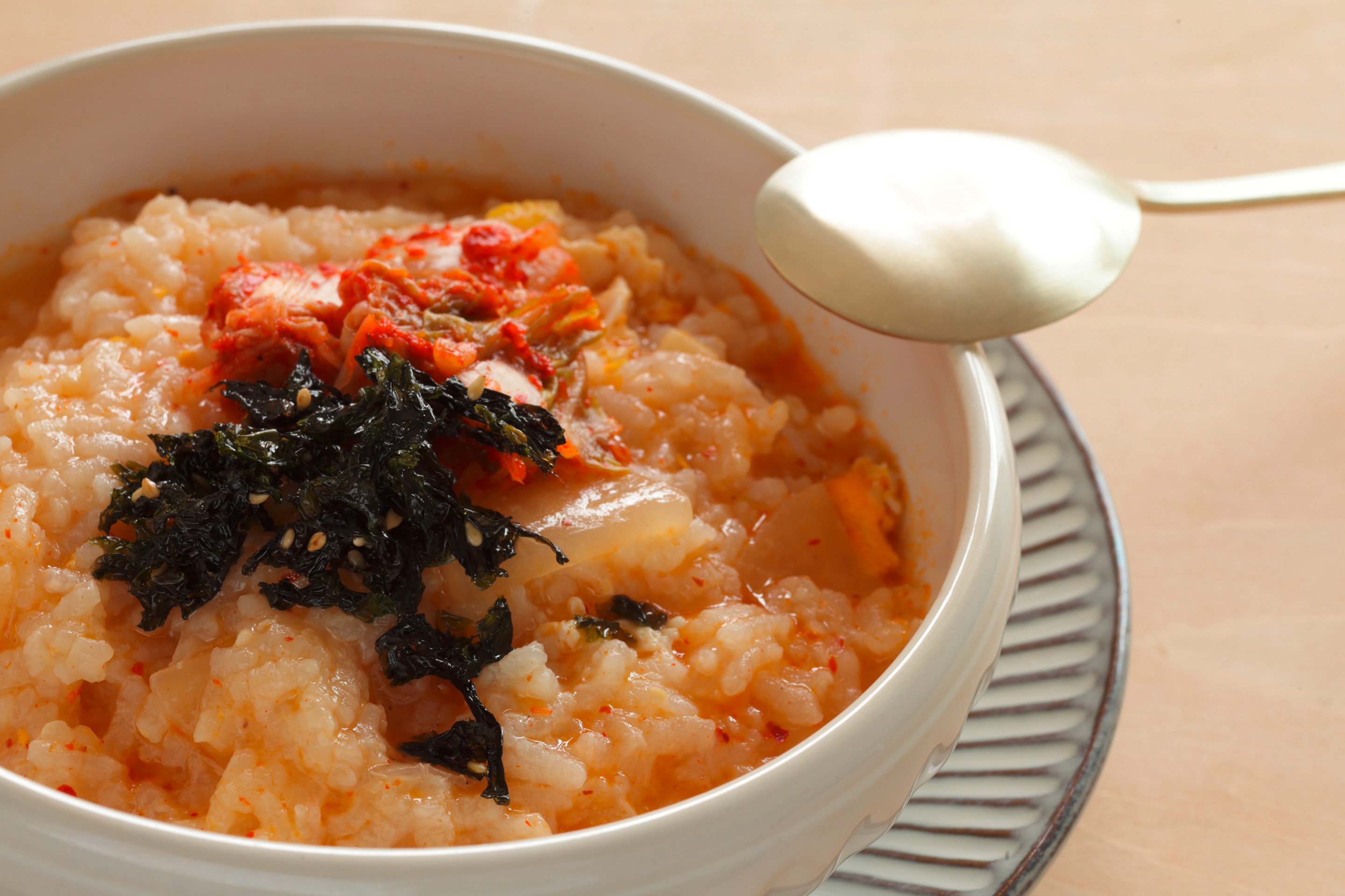 A bowl of porridge flavored with kimchi and seaweed