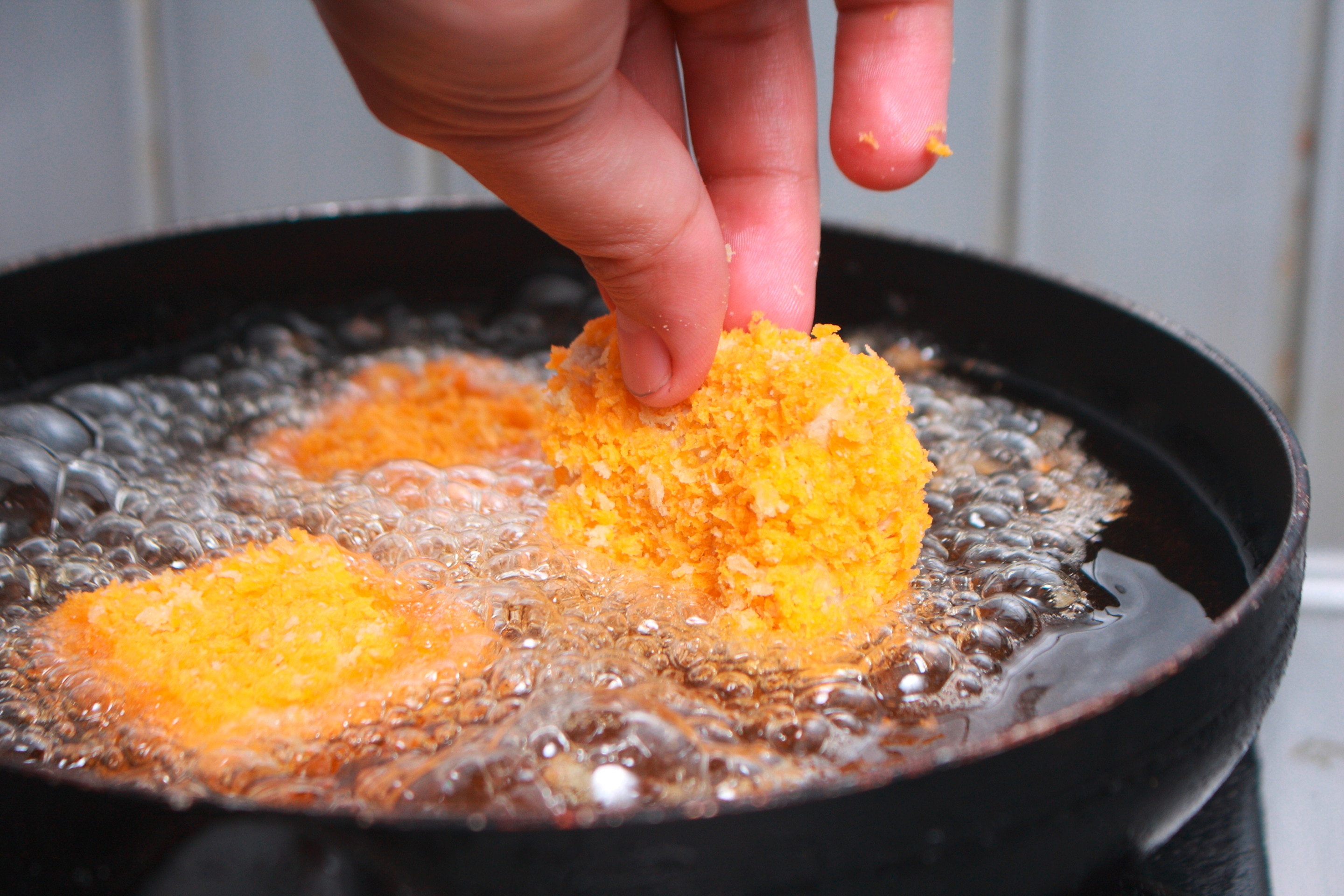 Chicken nugget being dropped into hot oil
