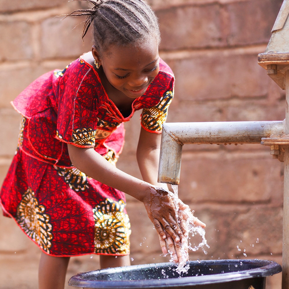 Beautiful girl washing her hands with running tap water