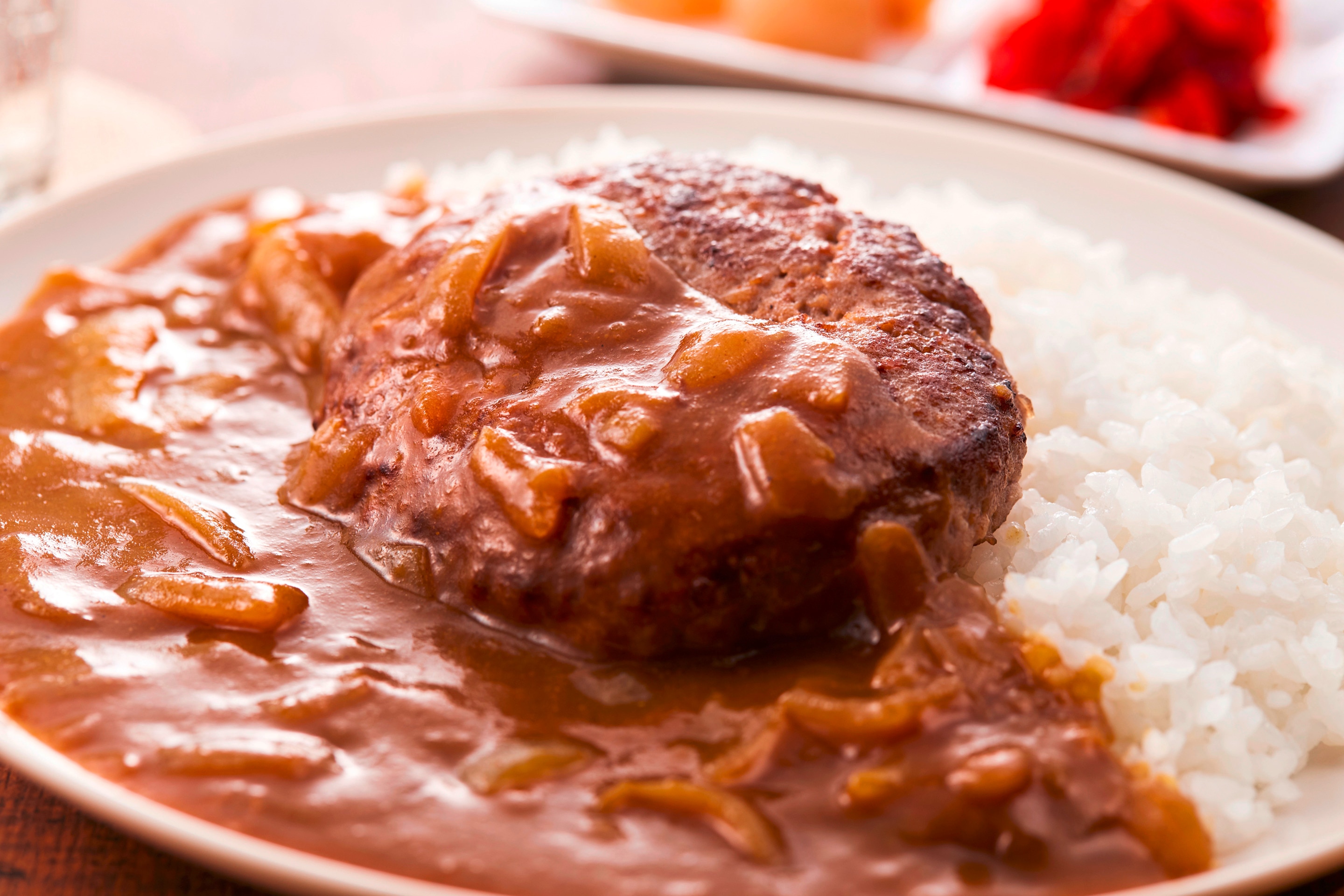 A plate of hamburger steak with gravy and rice