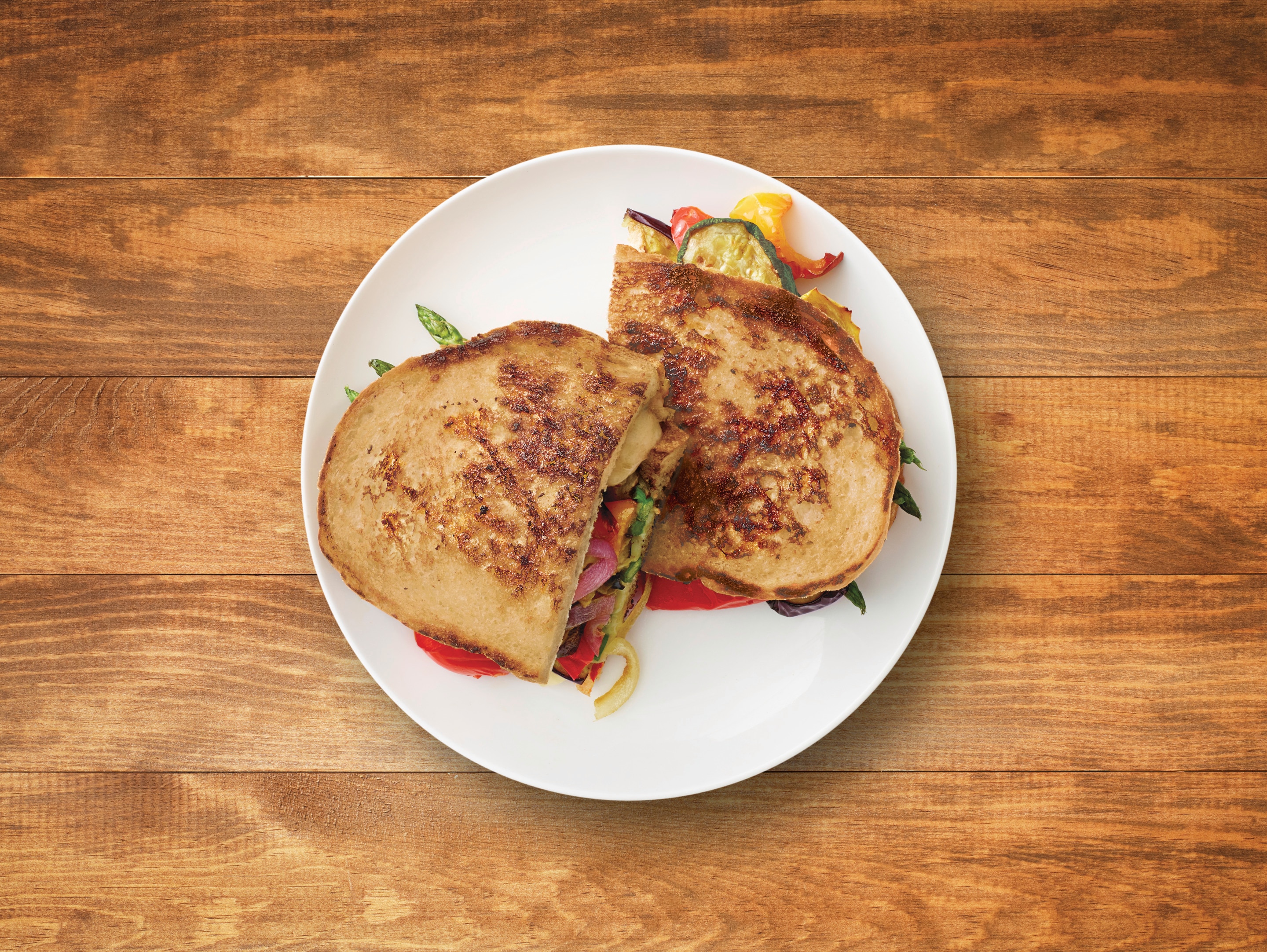 The top view of Perfectly Crispy Grilled Cheese & Veggie Strangewich served on the white plate on wooden surface