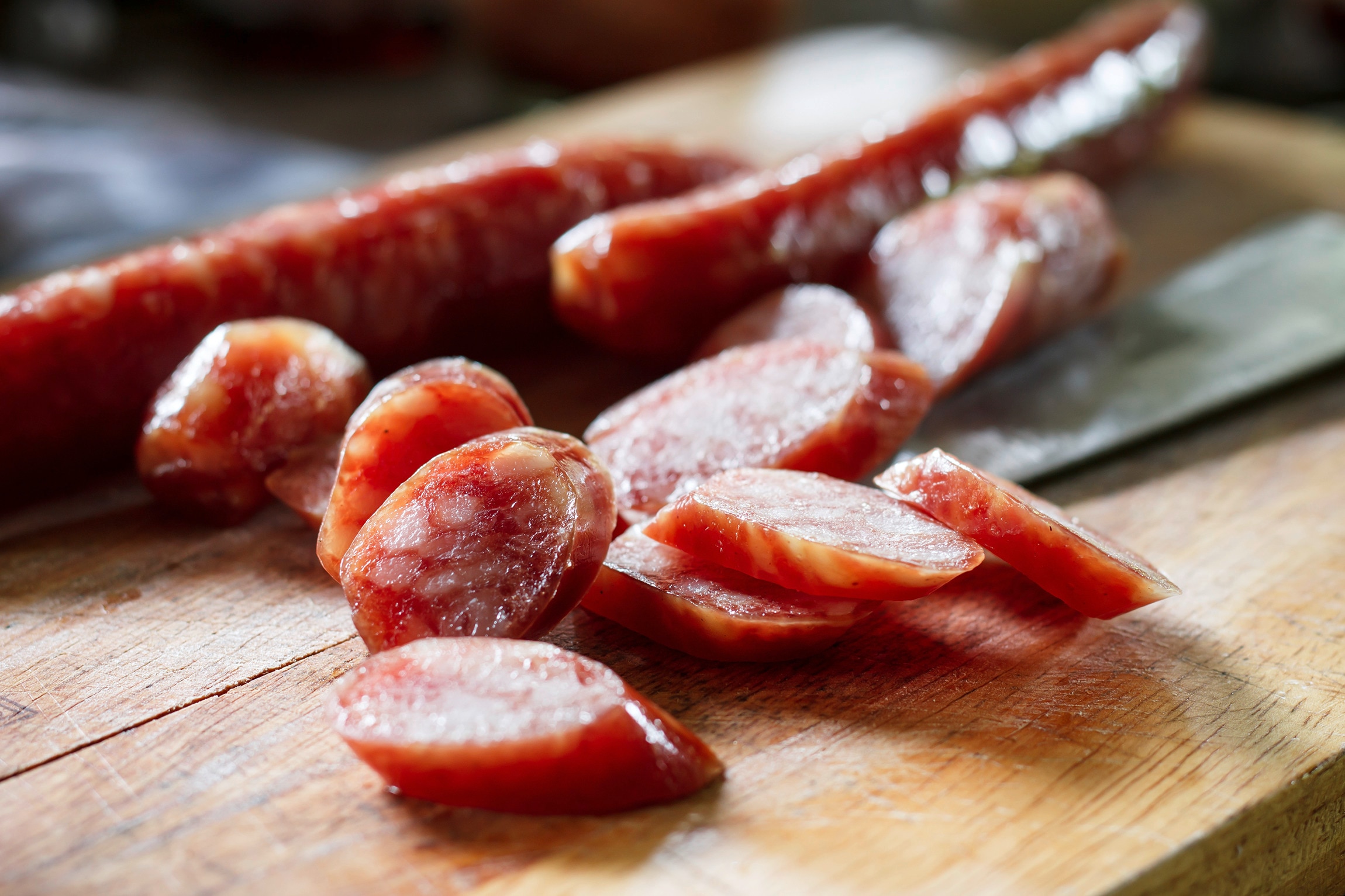 Slices of Chinese sausage on a wooden chopping board