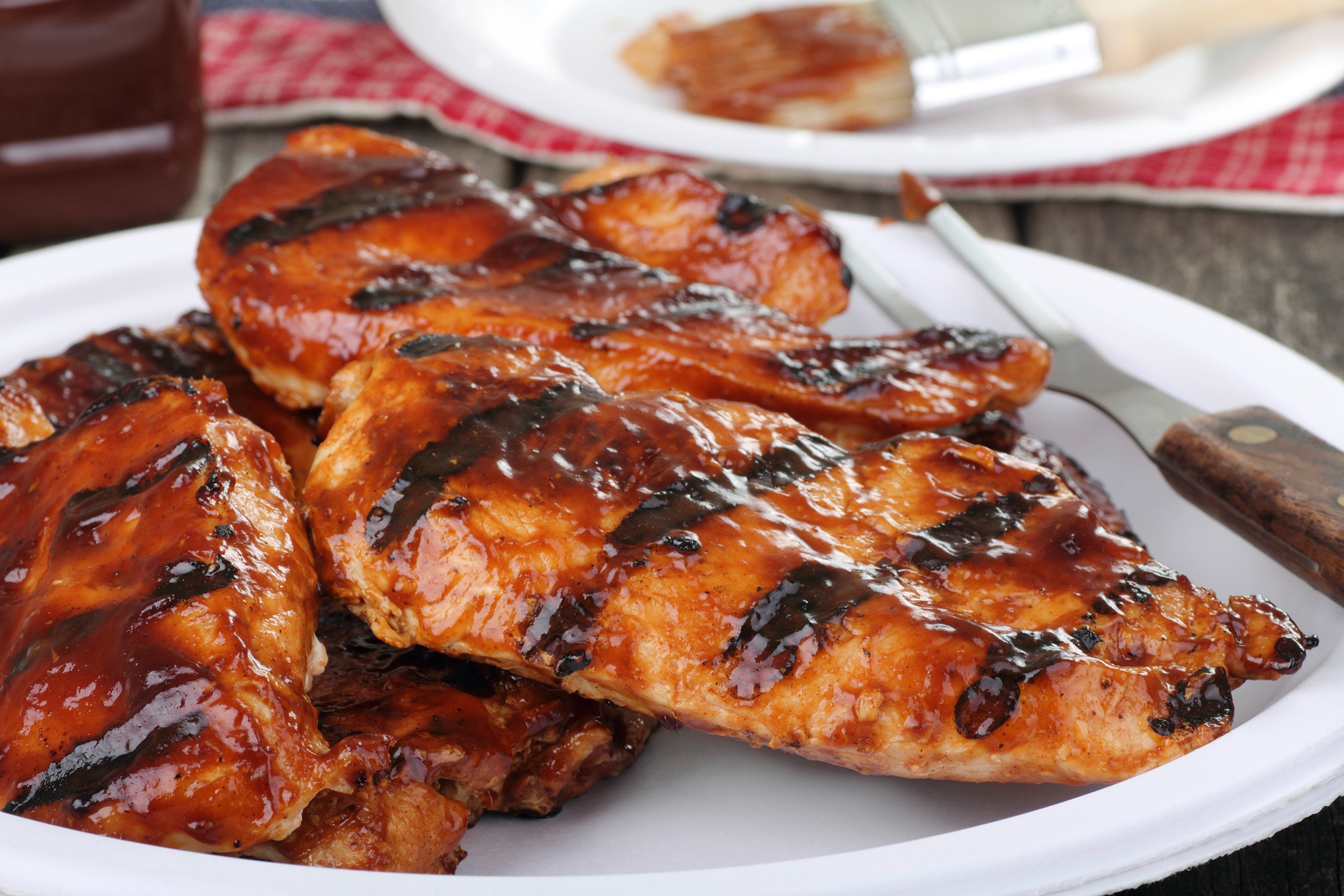 A plate of barbecue chicken breasts with lots of sauce